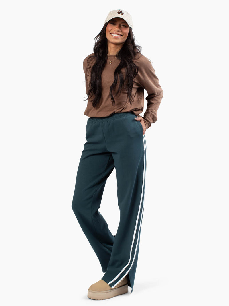 Tall woman wearing the Varsity Track Pants with white lines down side