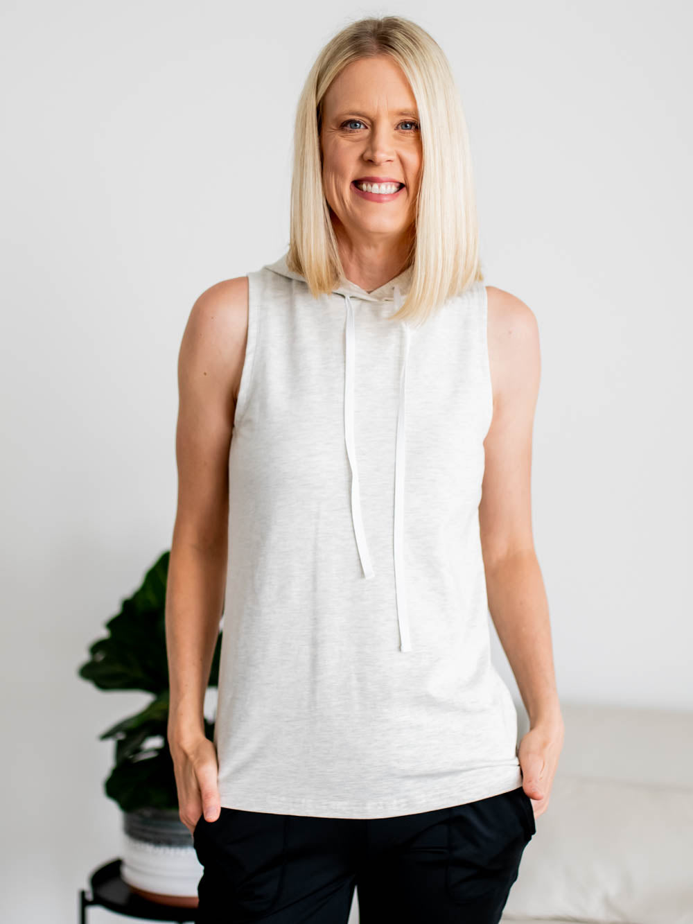 Tall woman wearing grey sleeveless hoodie tank