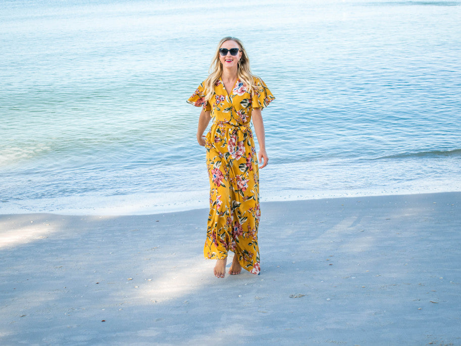 A floral faux wrap maxi dress with flutter sleeves in a deep mustard color
