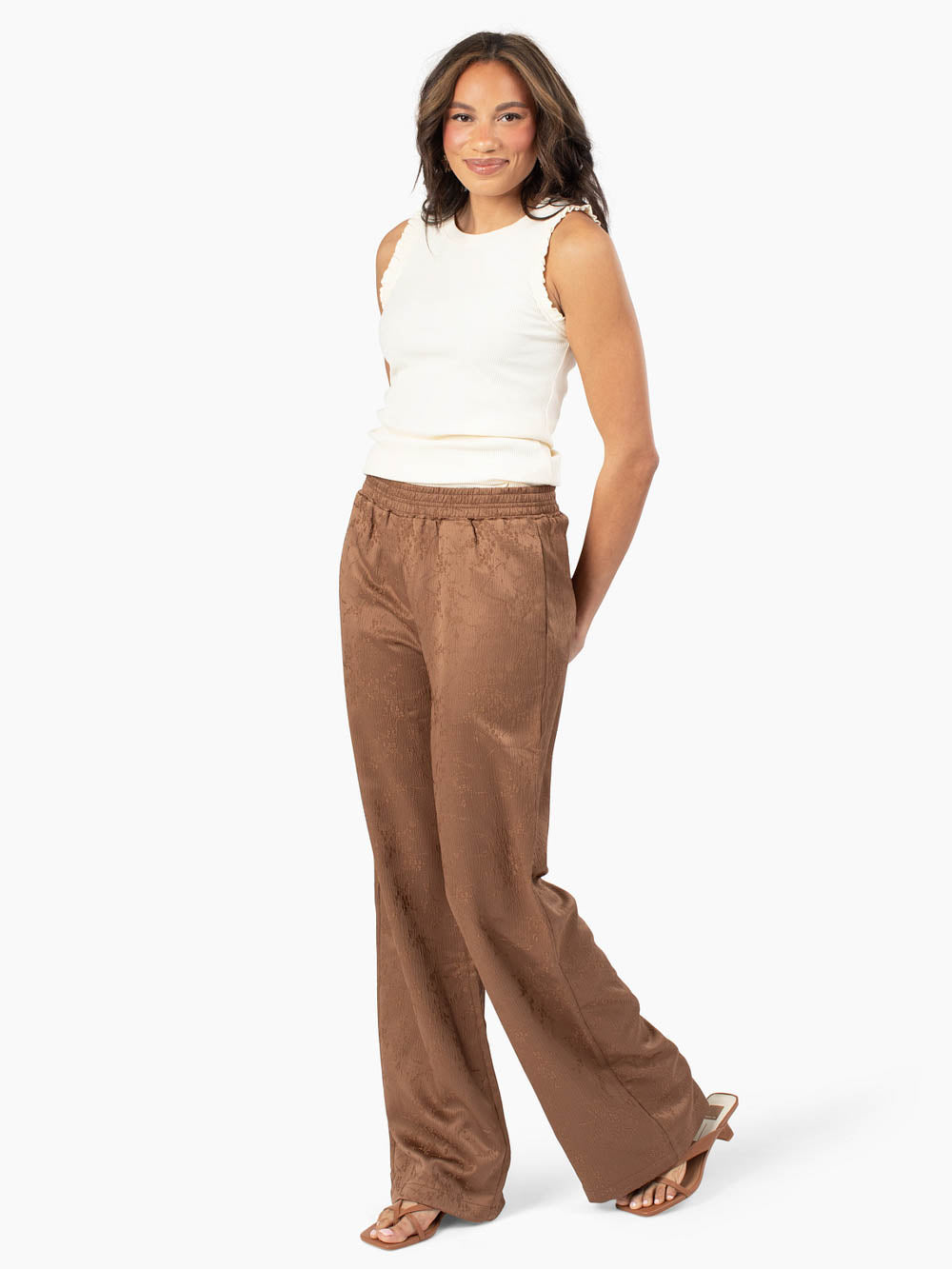 Tall model wearing Noelle floral wide leg pants in brown with cream tank