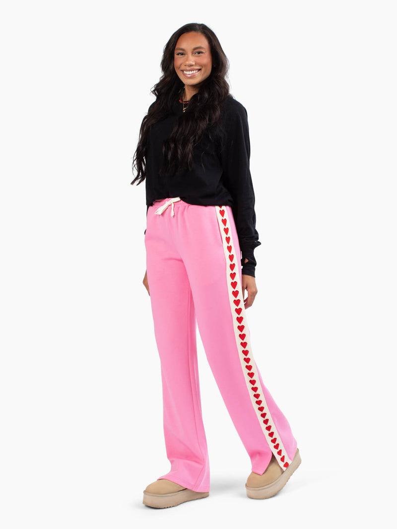 Tall woman wearing the Sweetheart Track Pants with crochet heart trim