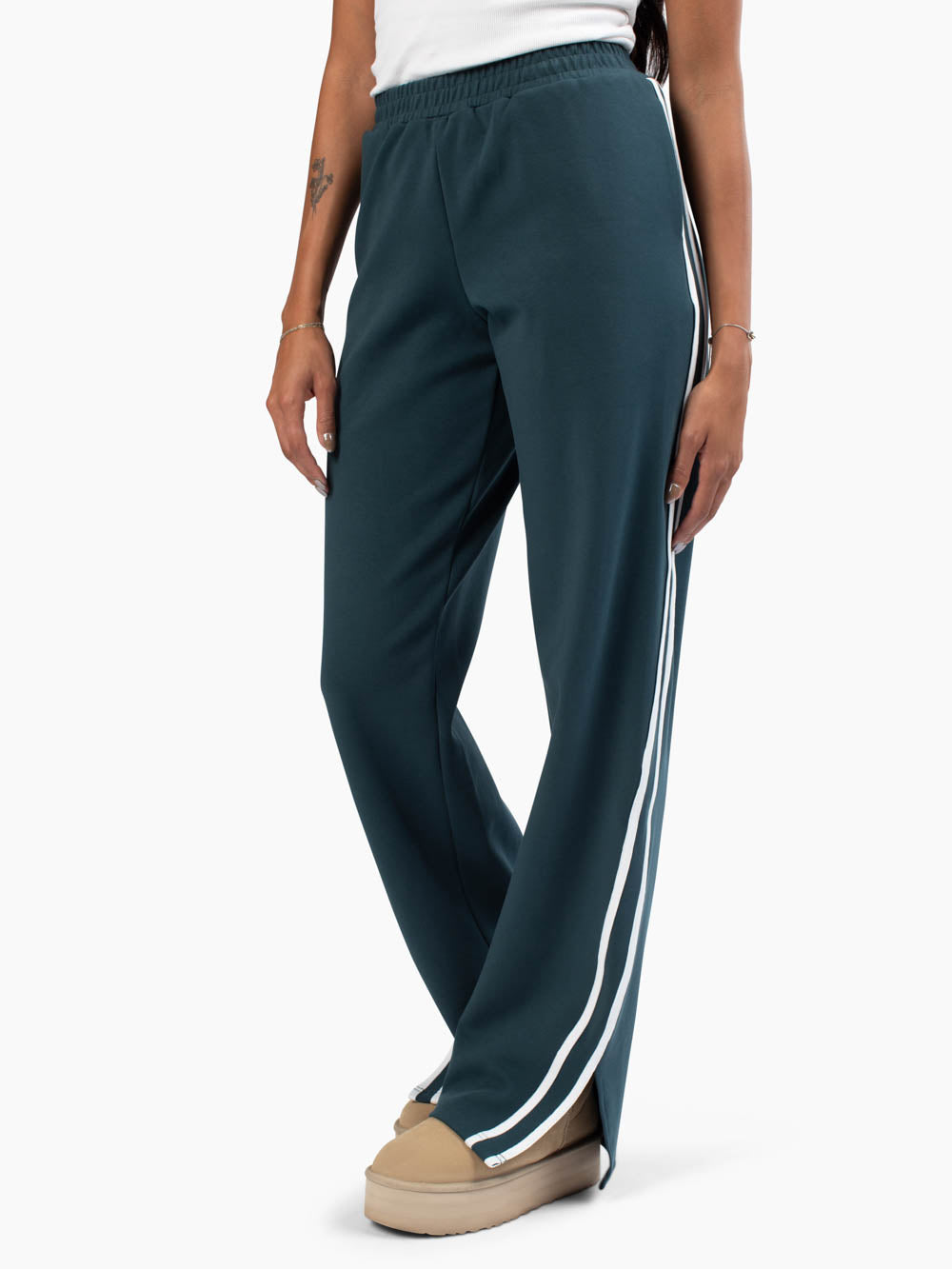 Tall woman wearing jade sweatpants with white lines