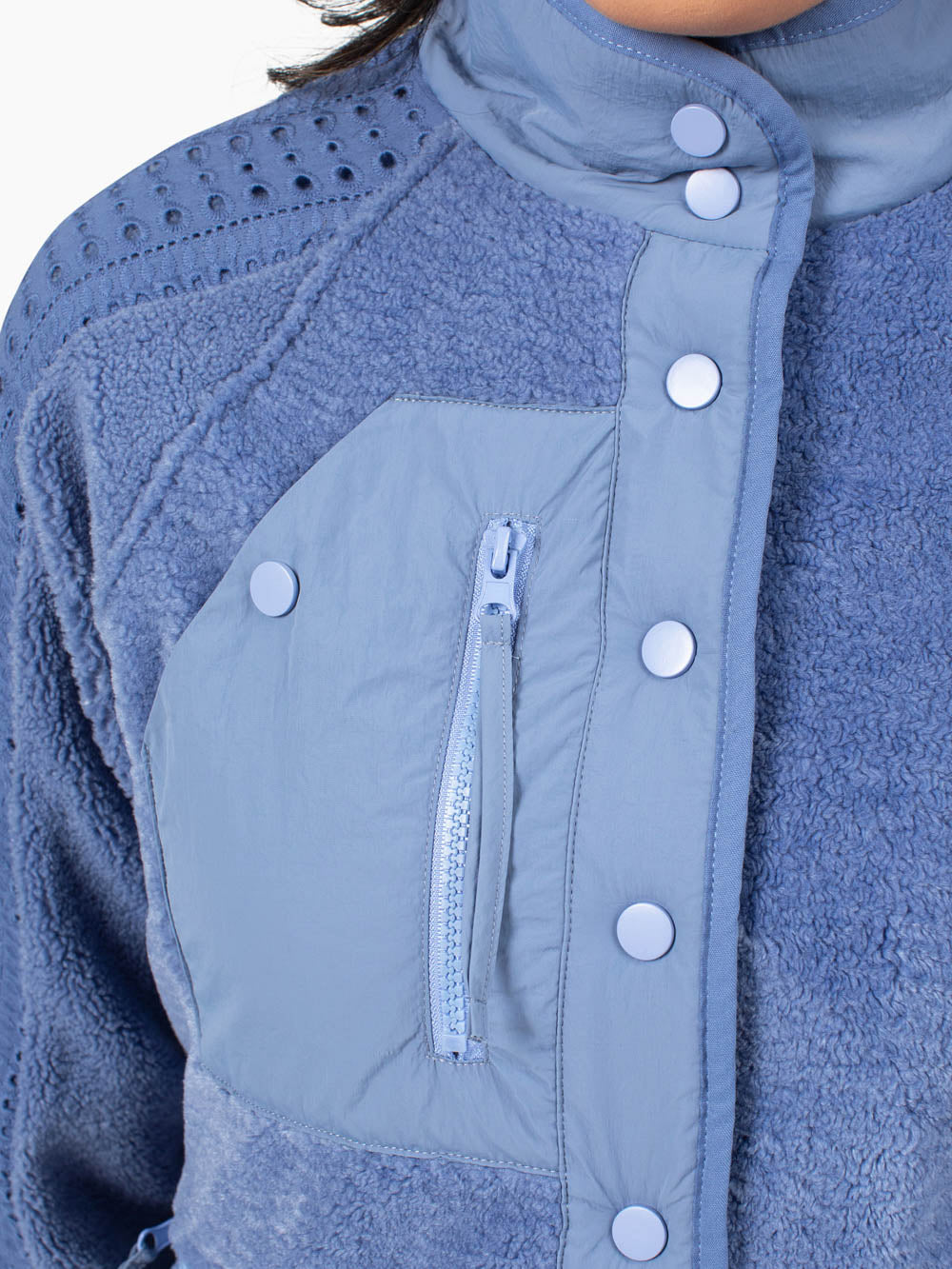 Close-up of decorative zipper chest detail and hidden snap pocket on Juniper fleece jacket