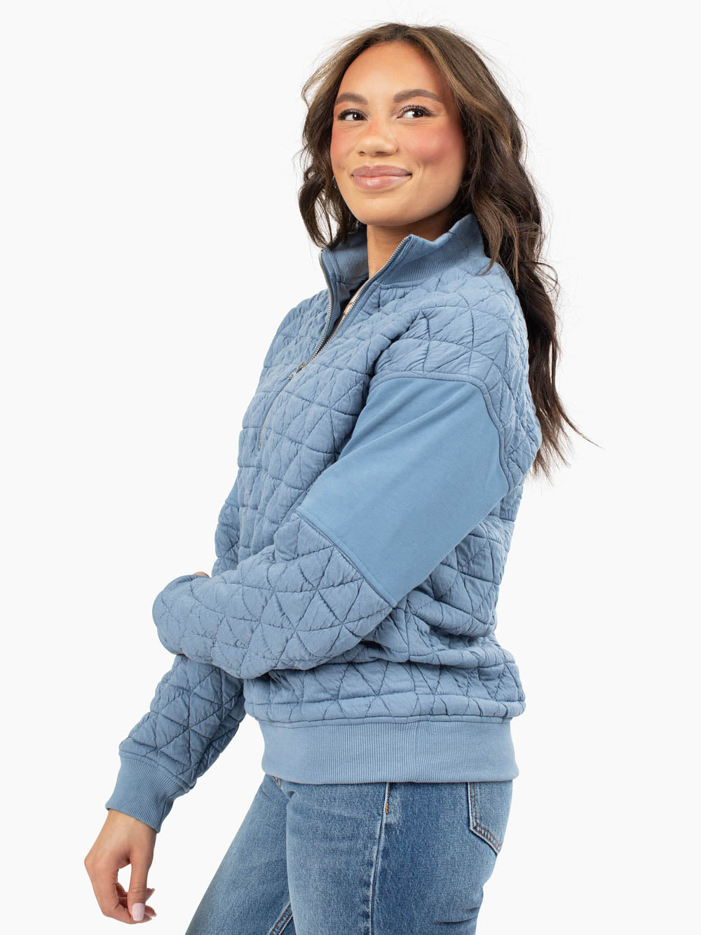 Side view of blue quilted half zip showing tall-friendly sleeve length