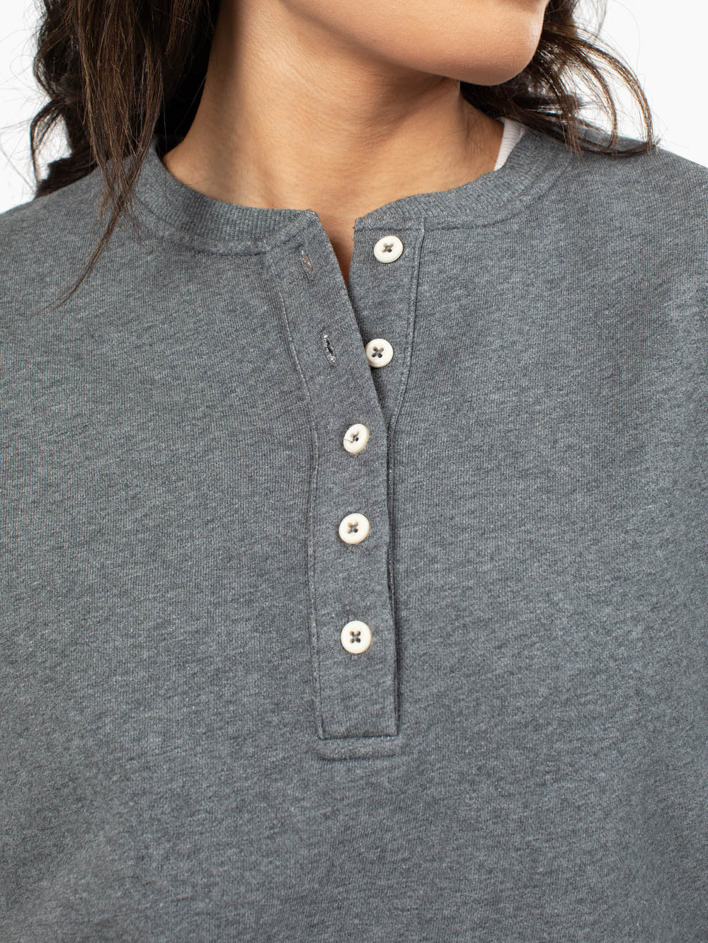 Close-up of henley button detail on charcoal sweatshirt