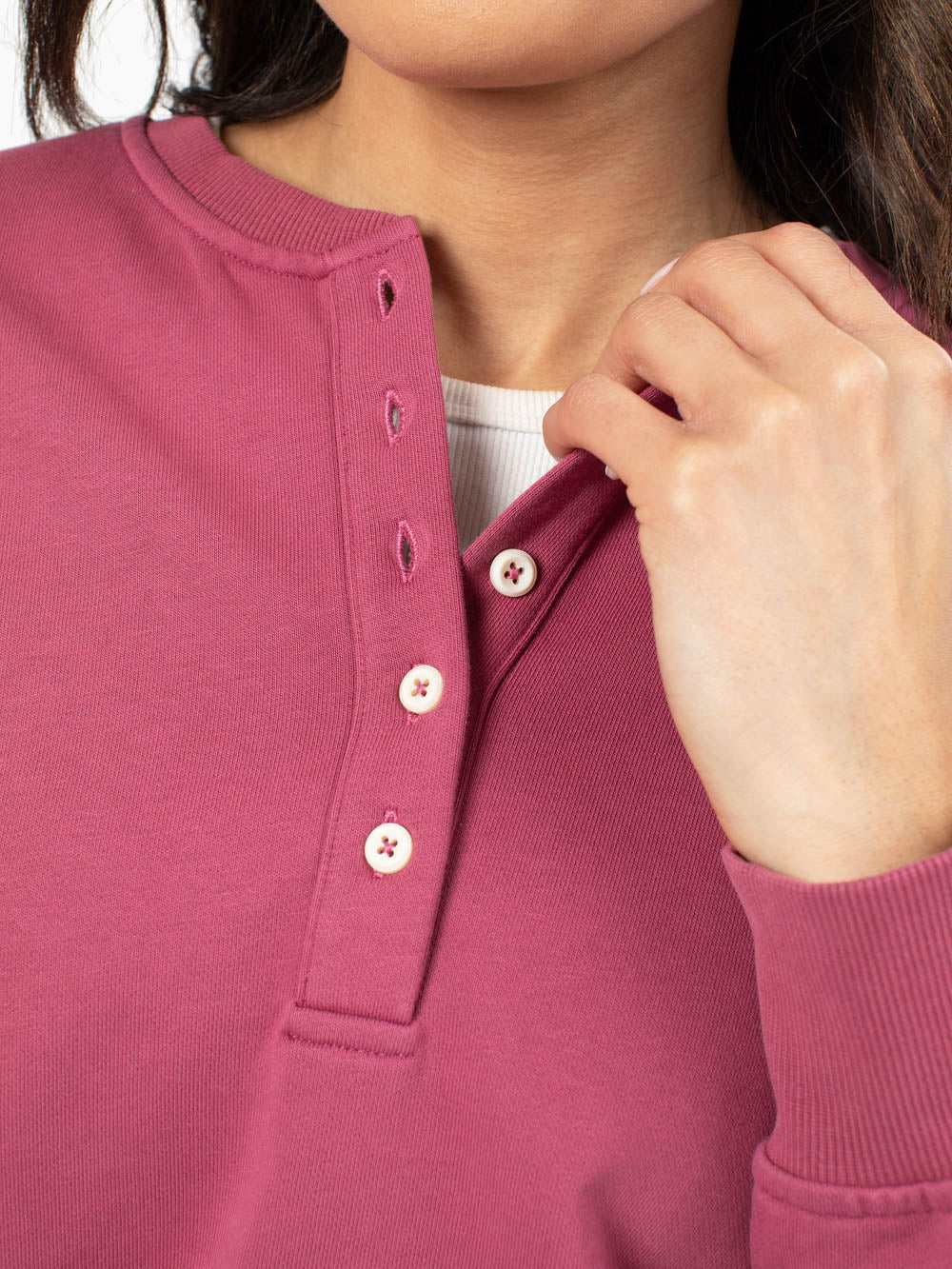 Close-up of henley button neckline on raspberry sweatshirt
