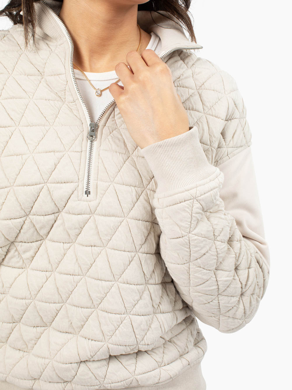 Close-up of quilted texture on mushroom half zip sweatshirt