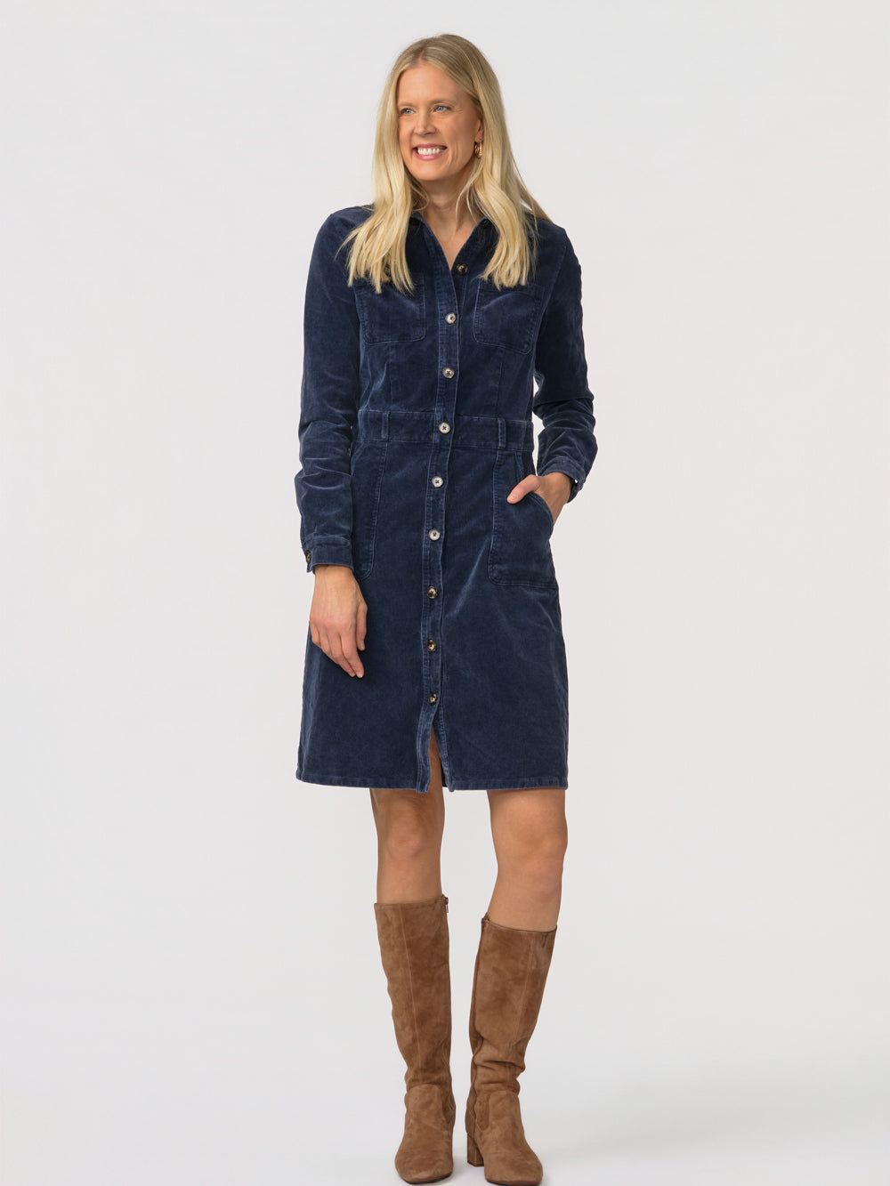 Tall woman in the navy Odette cord shirt dress with hands in the hip pockets