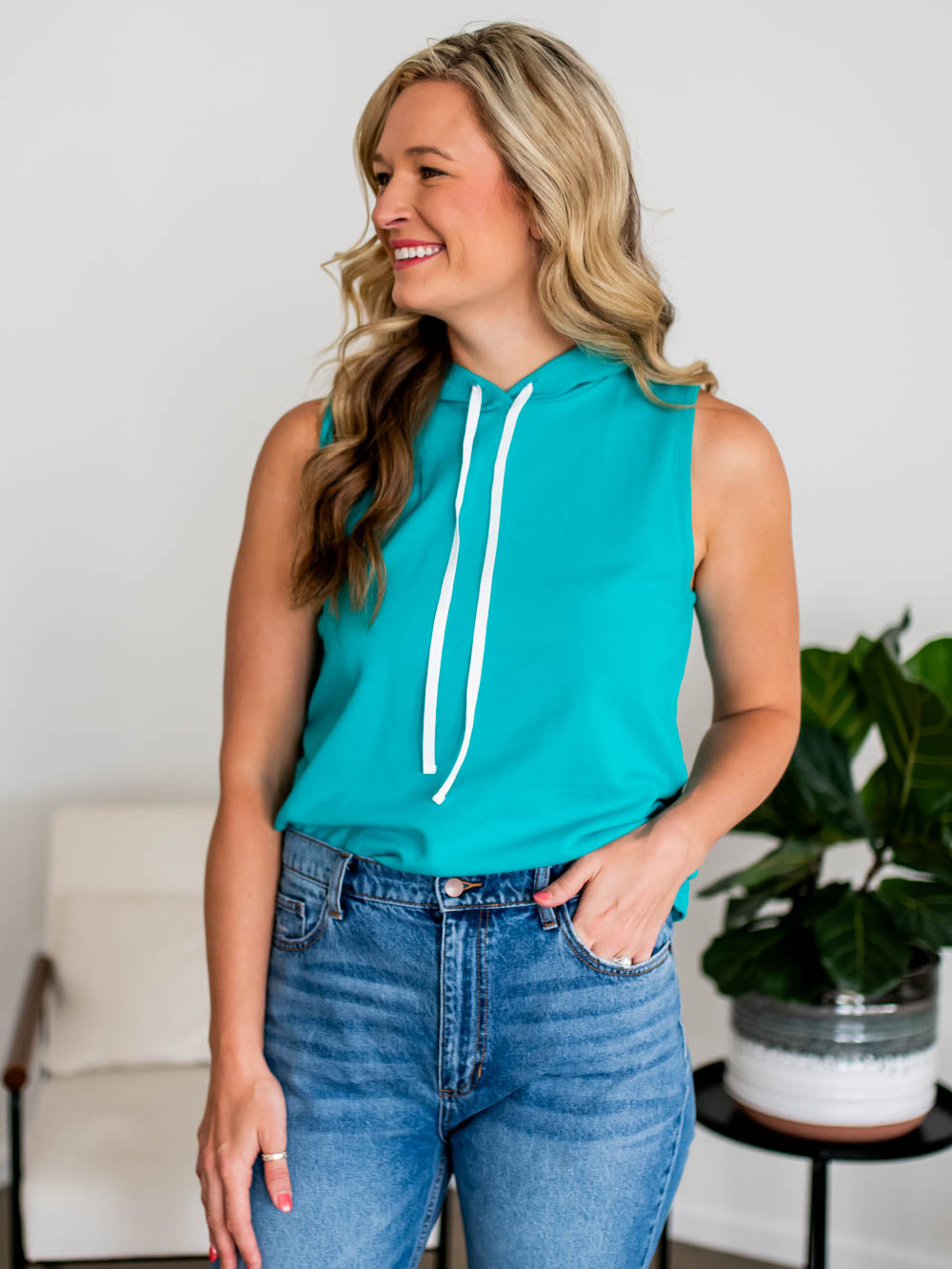 Tall woman wearing Caribbean blue Sideline Tank with high-rise jeans
