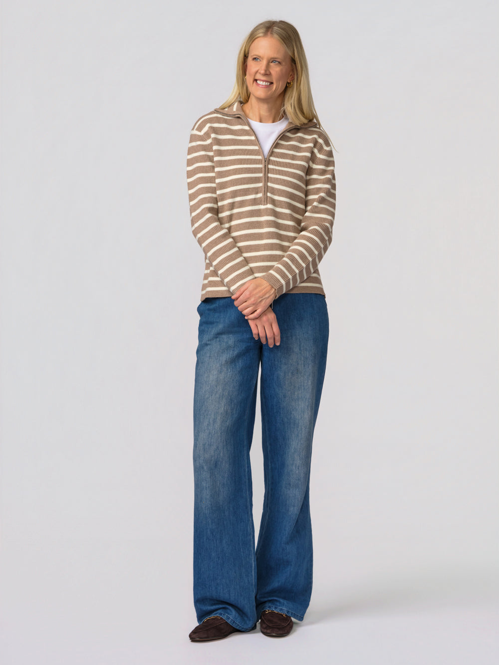 Tall woman wearing the Tatum taupe and cream striped quarter zip over a white tee